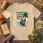 The Go Away I'm On Island Time sloth tee laid out with island travel keepsakes