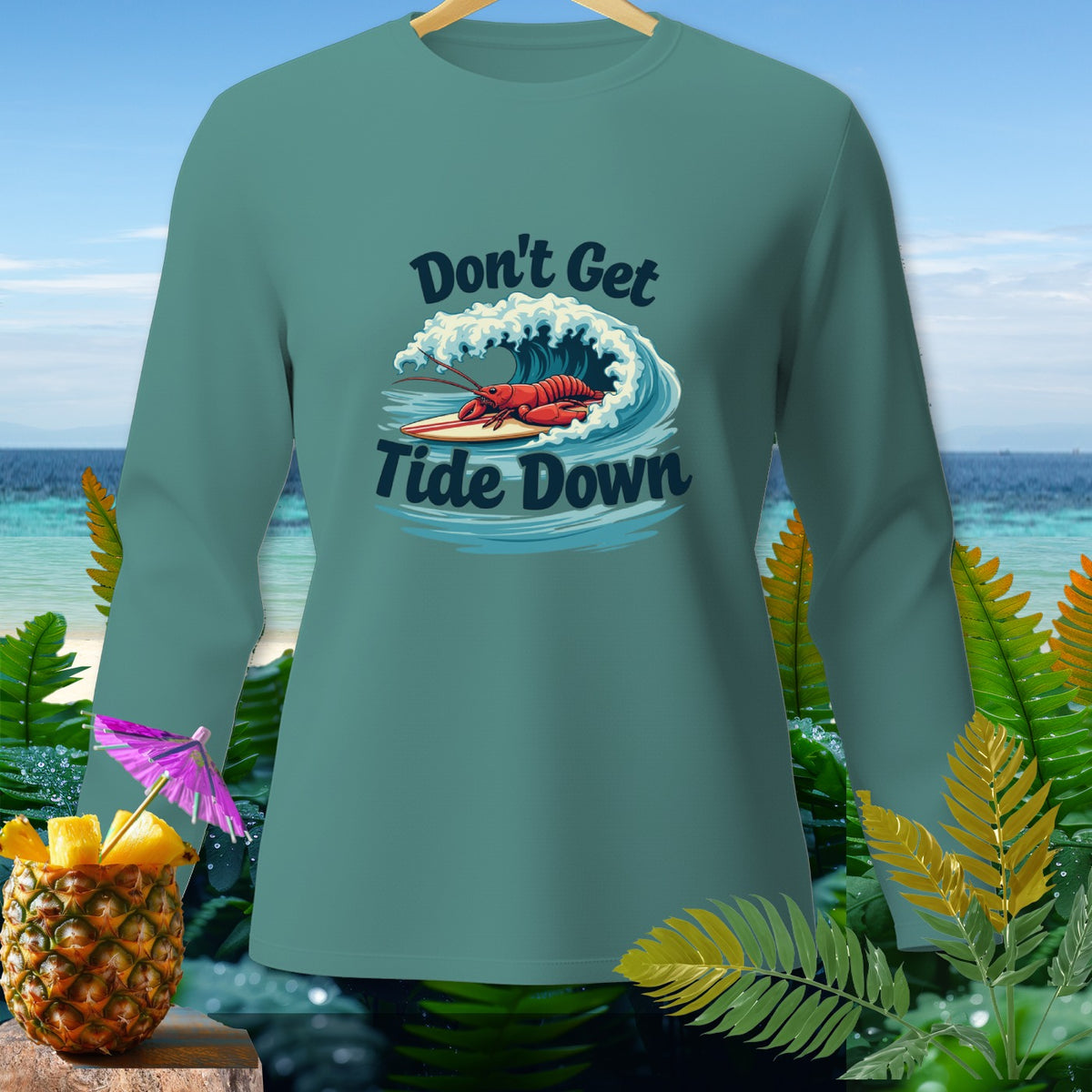 Teal long-sleeve shirt with lobster surfing graphic and text "Don't Get Tide Down".