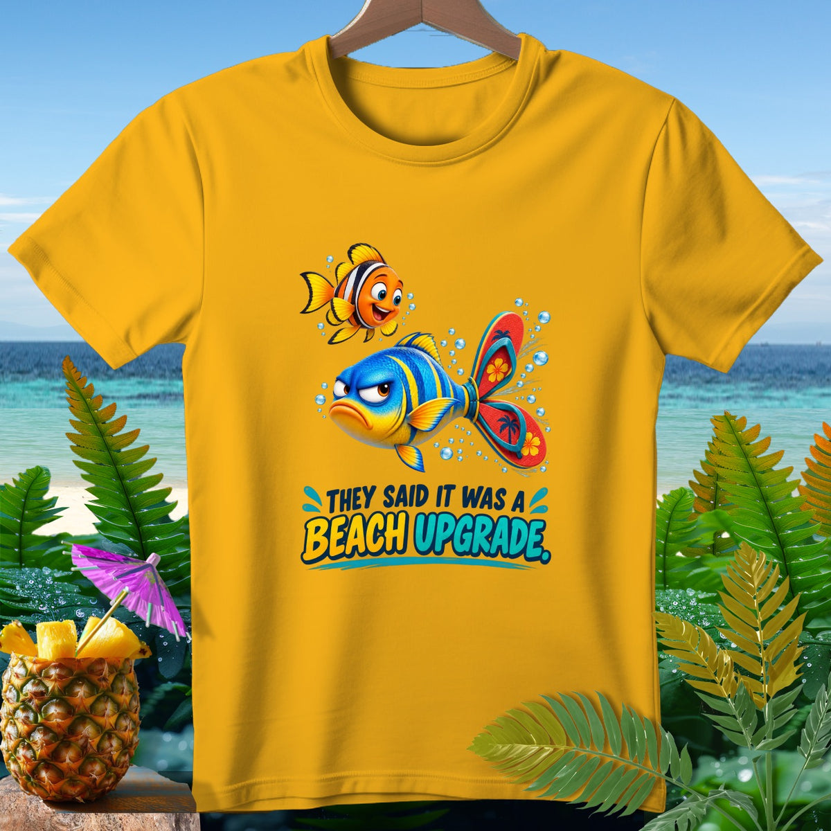 Yellow t-shirt with cartoon fish graphic and text "THEY SAID IT WAS A BEACH UPGRADE."
