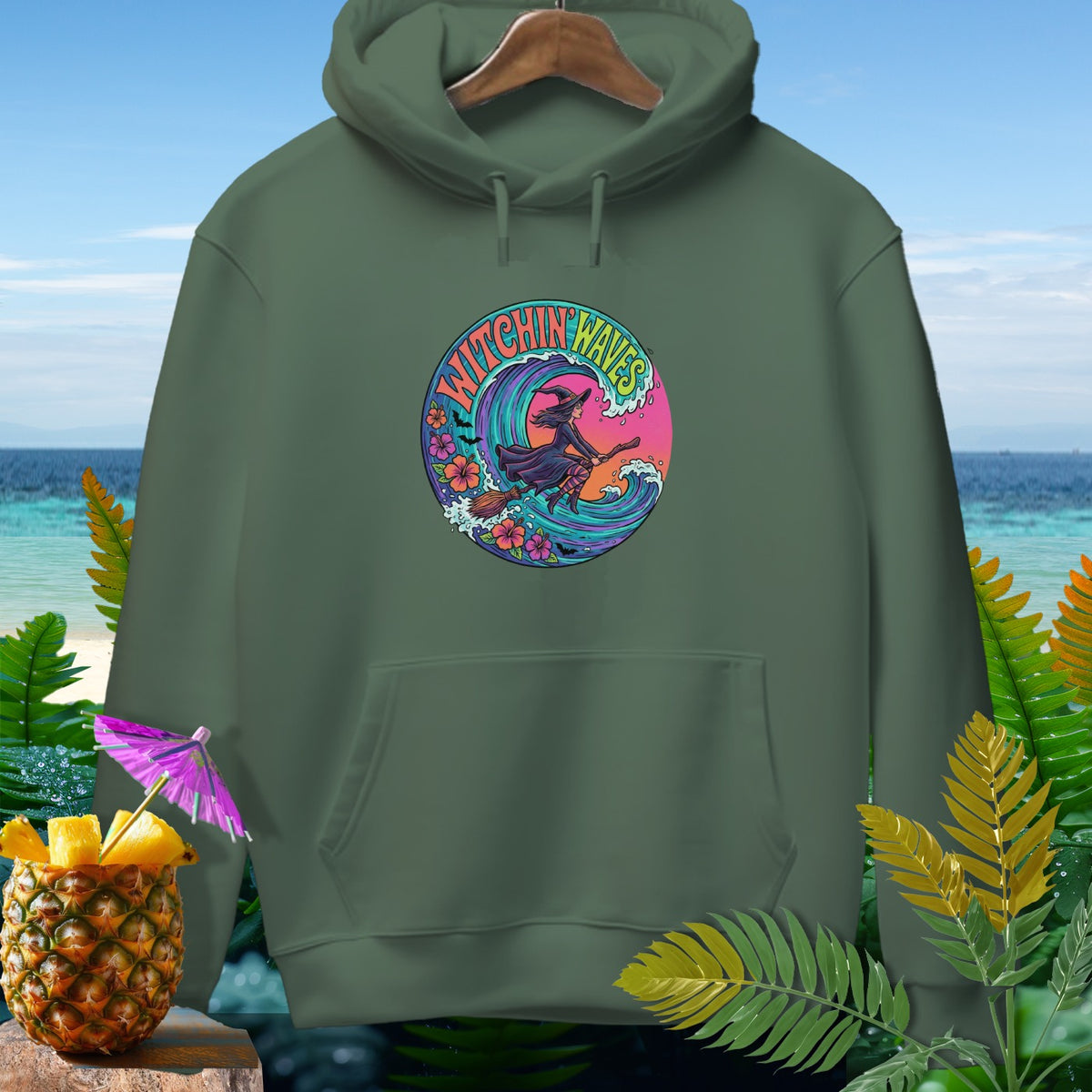 Green hoodie with circular "Witchin' Waves" graphic featuring a witch surfing a wave.