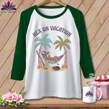 White t-shirt with green sleeves, featuring a witch in a hammock with text 