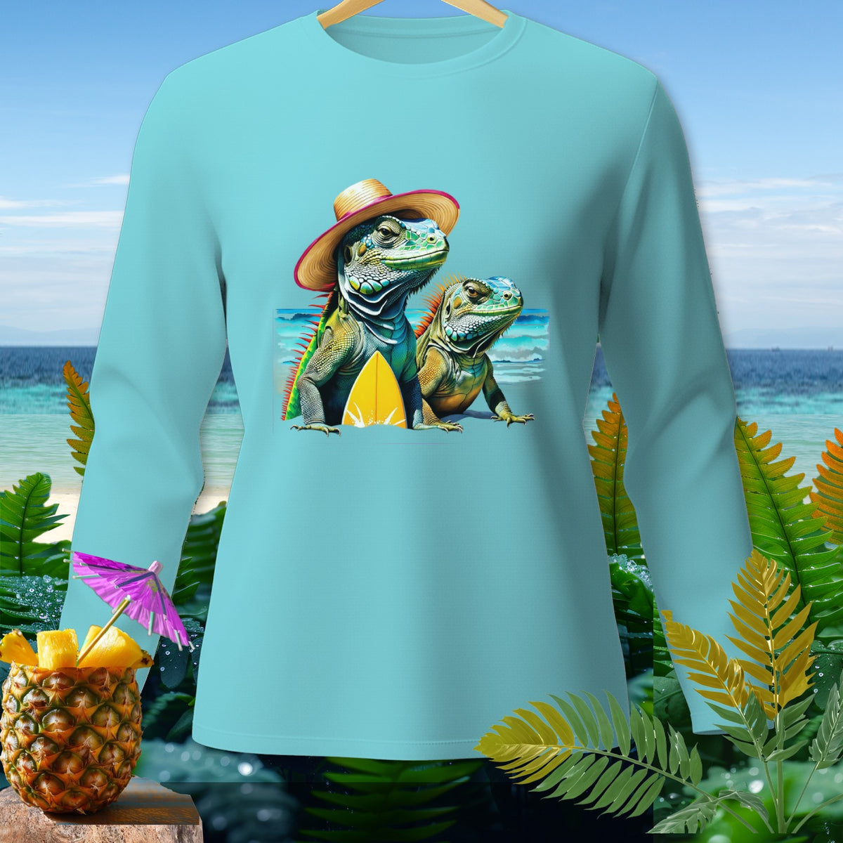 Two iguanas wearing hats with a surfboard on a beach, printed on a light blue long-sleeve shirt.