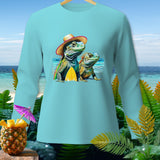 Two iguanas wearing hats with a surfboard on a beach, printed on a light blue long-sleeve shirt.