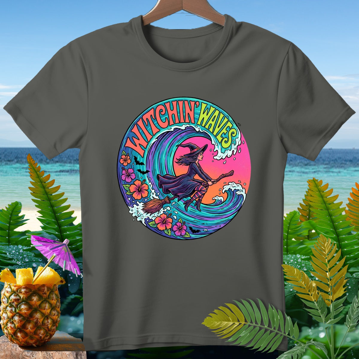Dark grey t-shirt with a circular graphic of a witch flying on a broomstick over a wave.