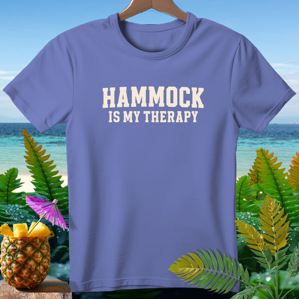 Periwinkle t-shirt with "HAMMOCK IS MY THERAPY" text, tropical background.