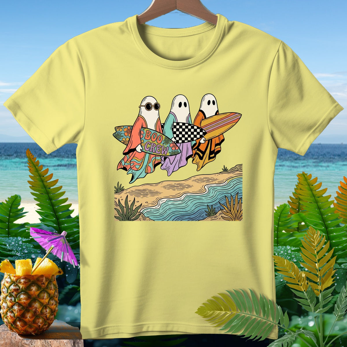 Yellow t-shirt with cartoon ghosts holding surfboards on a beach.