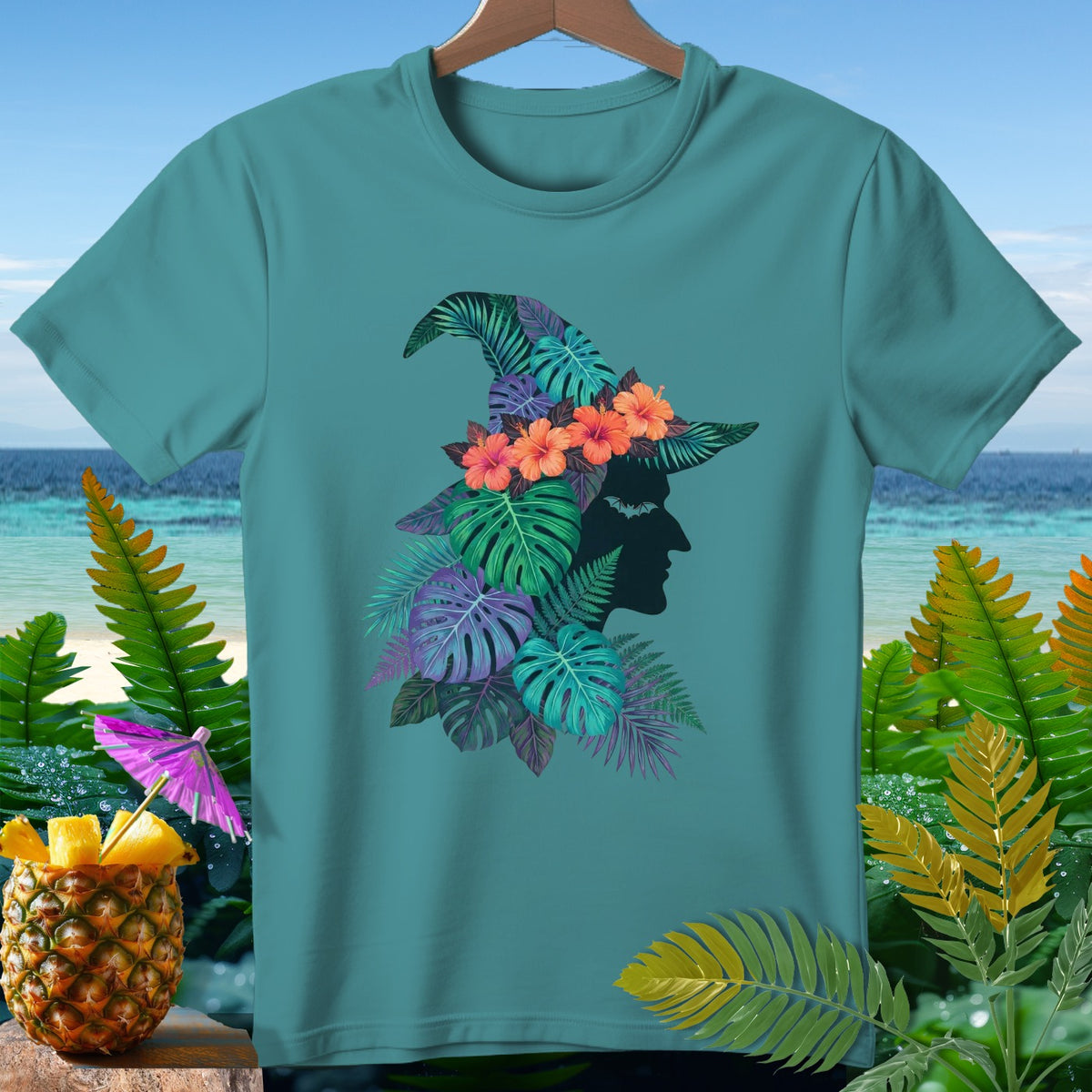 Teal t-shirt with a tropical witch hat design featuring silhouette profile and leaves.