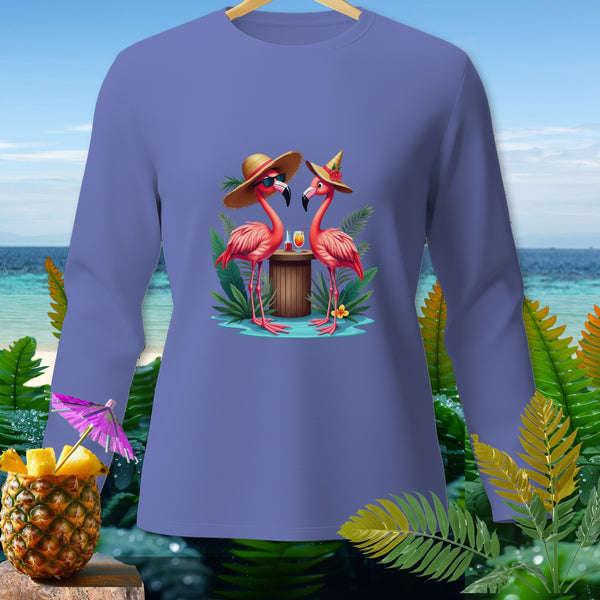 Two flamingos wearing hats and sunglasses with drinks on a tropical beach.