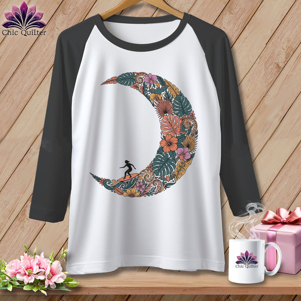 White baseball tee with a floral crescent moon design and surfer silhouette.