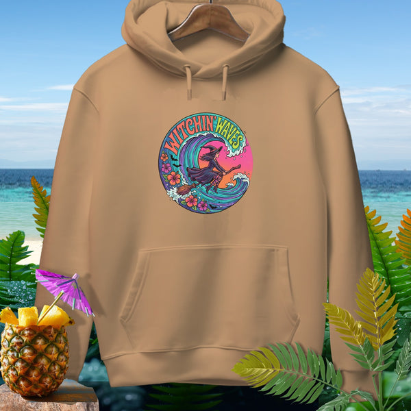 Tan hoodie with "Witchin' Waves" graphic of a witch riding a broomstick on a wave.