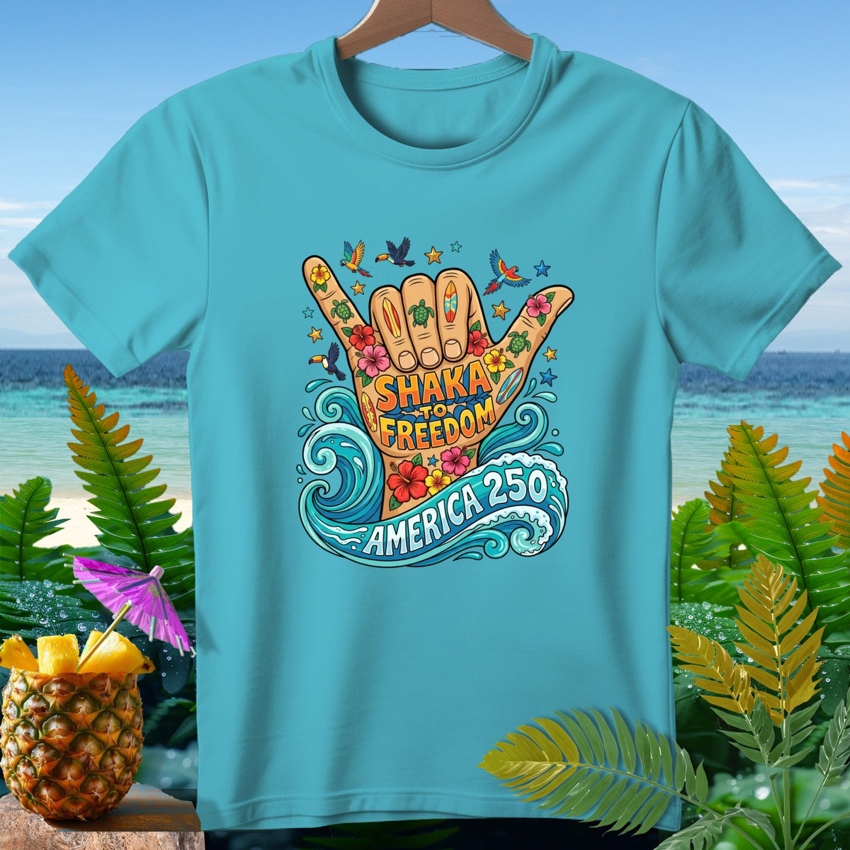 Aqua t-shirt with a shaka hand graphic and text "SHAKA TO FREEDOM AMERICA 250".
