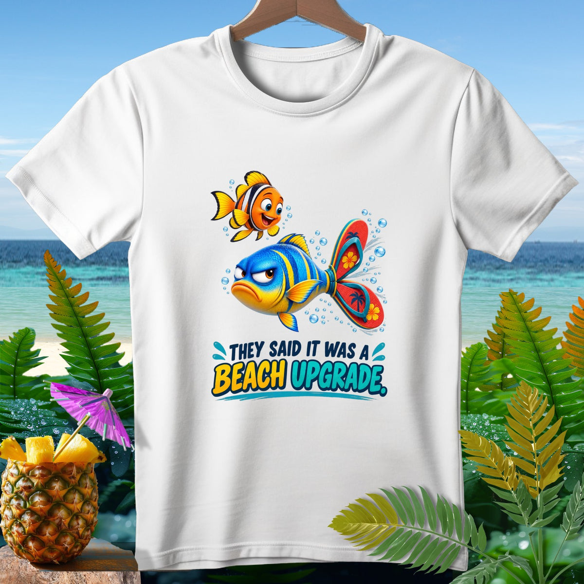 White t-shirt with cartoon fish and text "THEY SAID IT WAS A BEACH UPGRADE."