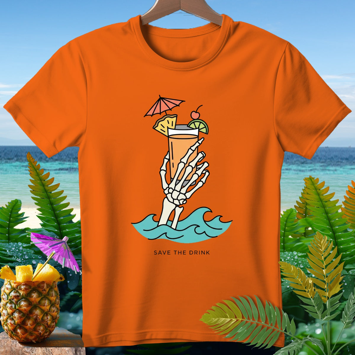 Orange t-shirt with skeleton hand holding a tropical drink with text "SAVE THE DRINK".