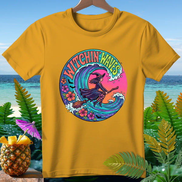 Yellow t-shirt with circular graphic of witch on broom, text "Witchin Waves", waves, and flowers.