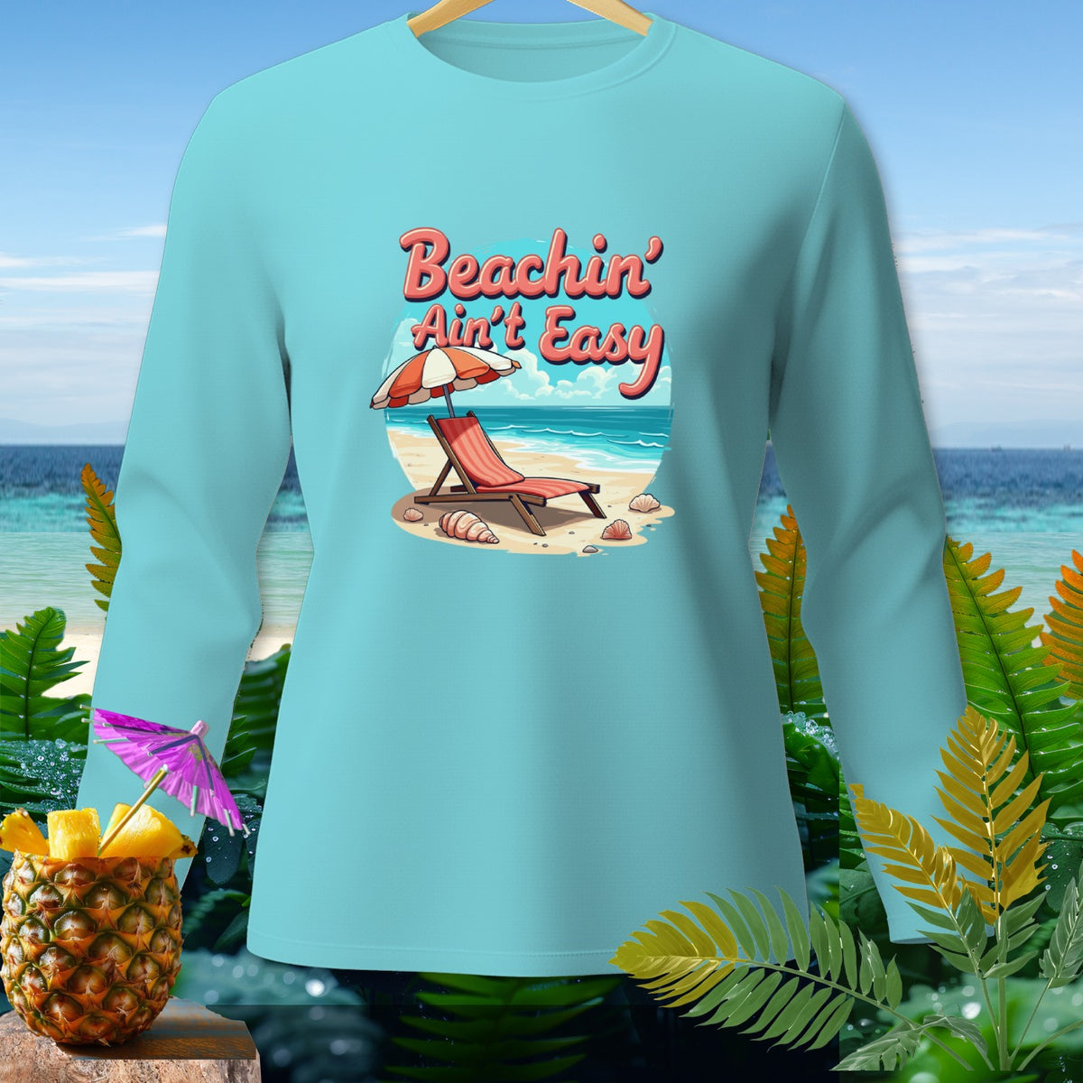 Light blue long-sleeve shirt with "Beachin' Ain't Easy" graphic on a beach scene.