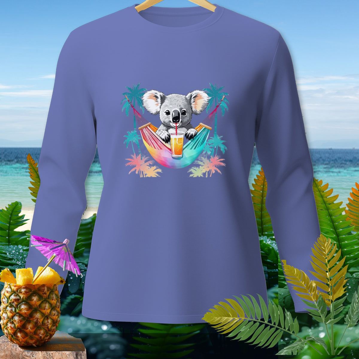 Long-sleeve shirt with a koala in a hammock drinking juice, palm trees, and beach background.