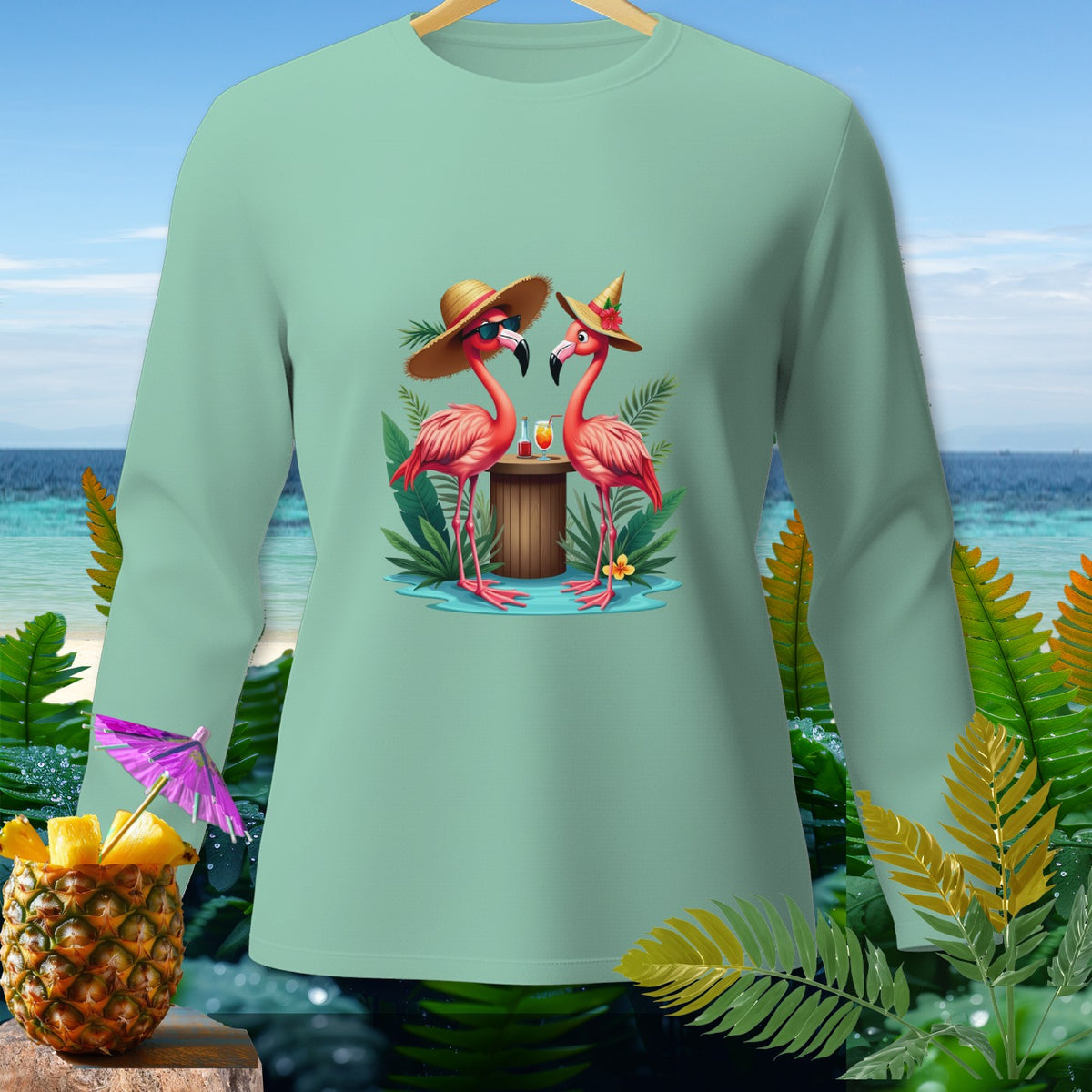 Mint long-sleeve shirt with two flamingos wearing straw hats and holding cocktails.