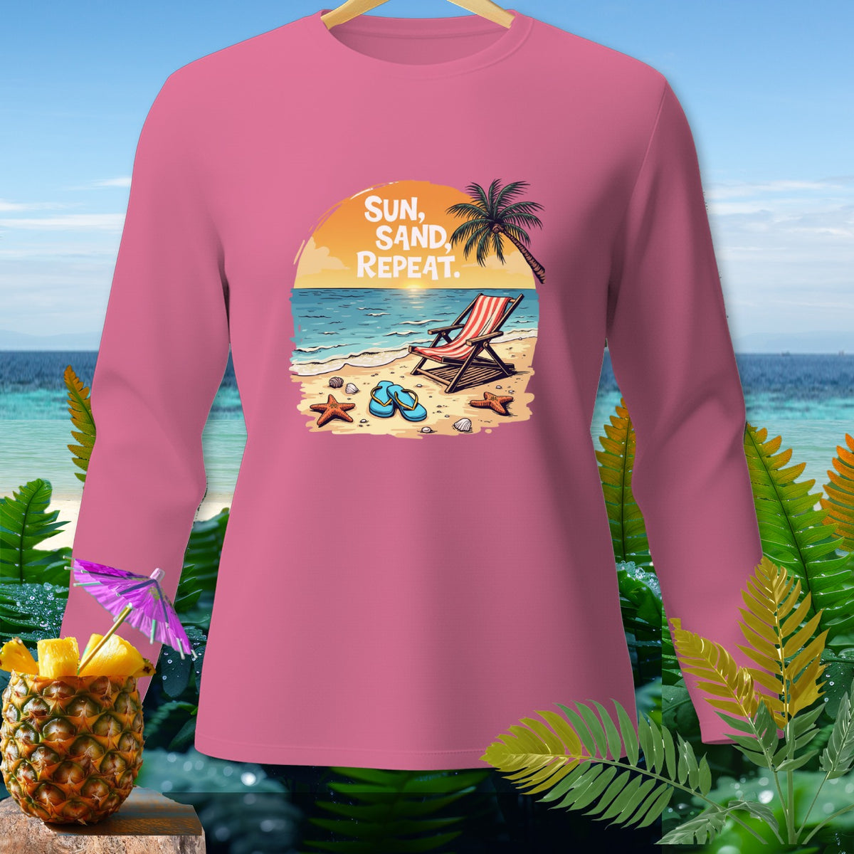Pink long-sleeved shirt with a beach graphic featuring a lounge chair, palm tree, and Sun, Sand, Repeat text.