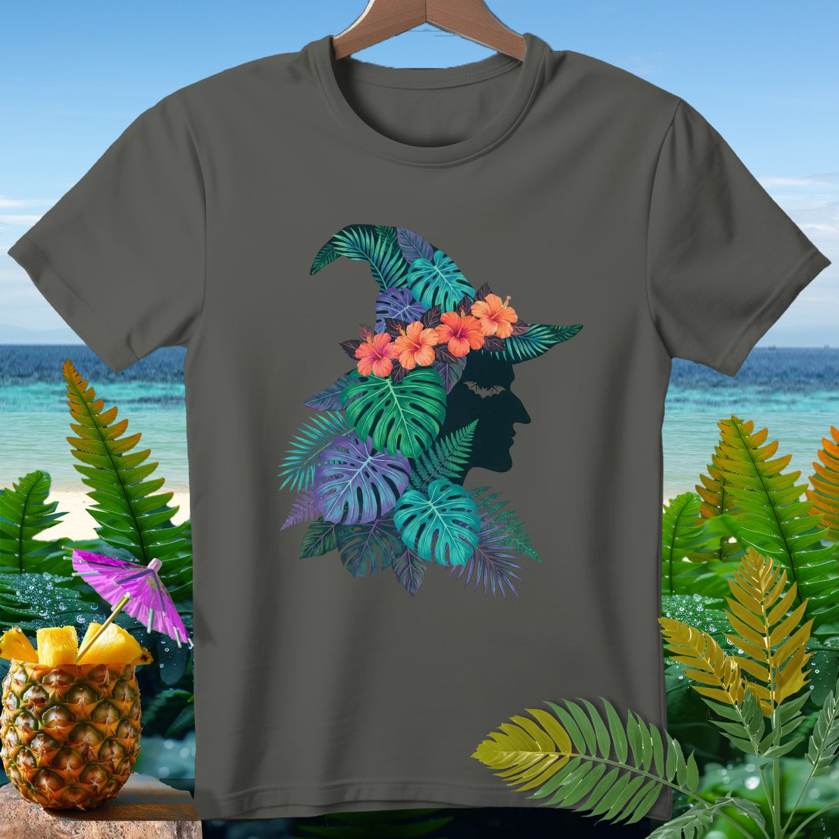 Dark grey t-shirt with a tropical witch hat graphic and a pineapple drink.