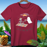 T-shirt with skeleton and ghost on a beach blanket, text 