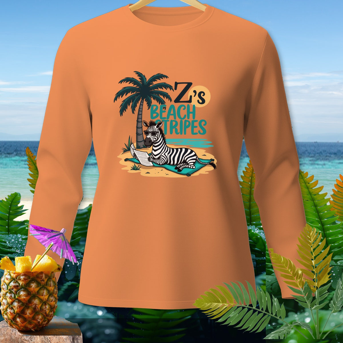Orange long-sleeved shirt with graphic of zebra on beach reading, "Z's BEACH TRIPES".