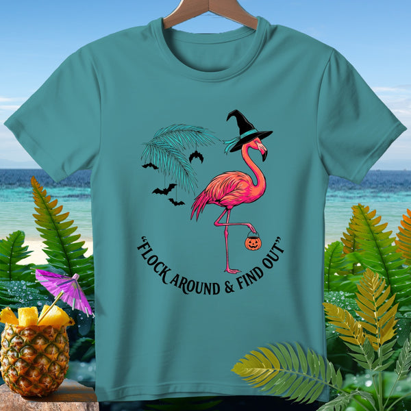 Teal t-shirt with pink flamingo in witch hat holding pumpkin, saying "Flock Around & Find Out."