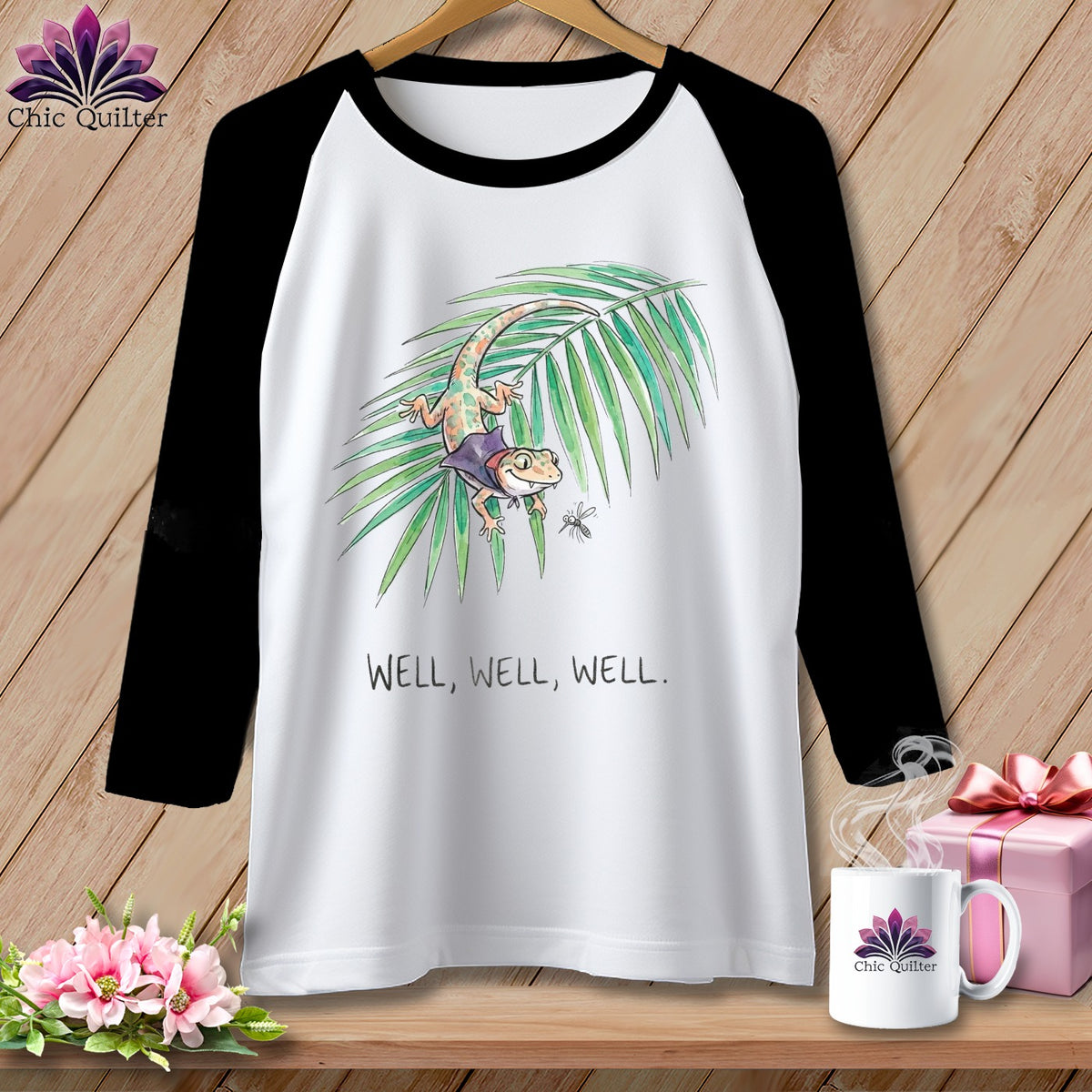 Raglan shirt with a cartoon gecko on a palm leaf and text "WELL, WELL, WELL."