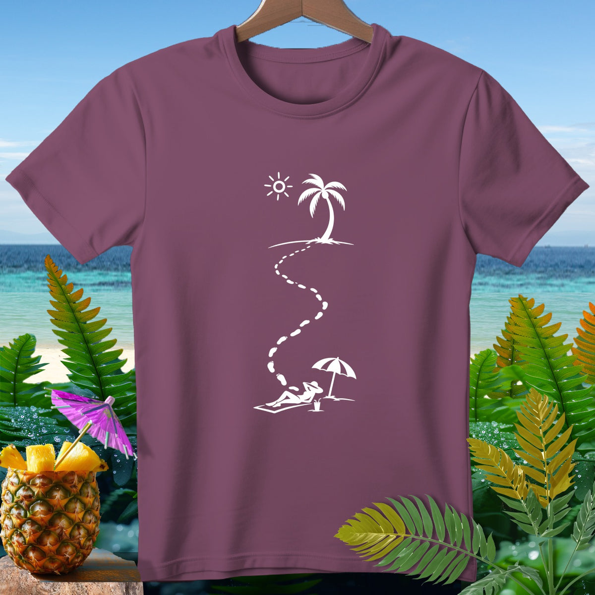 Maroon t-shirt with white graphic of footprints leading to a person relaxing on a beach under an umbrella.