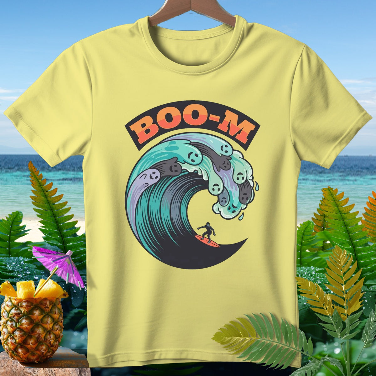 Yellow t-shirt with "BOO-M" and a surfer riding a wave with ghost faces.