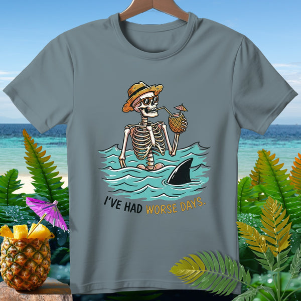 Skeleton in ocean with shark fin and pineapple drink, text "I'VE HAD WORSE DAYS."
