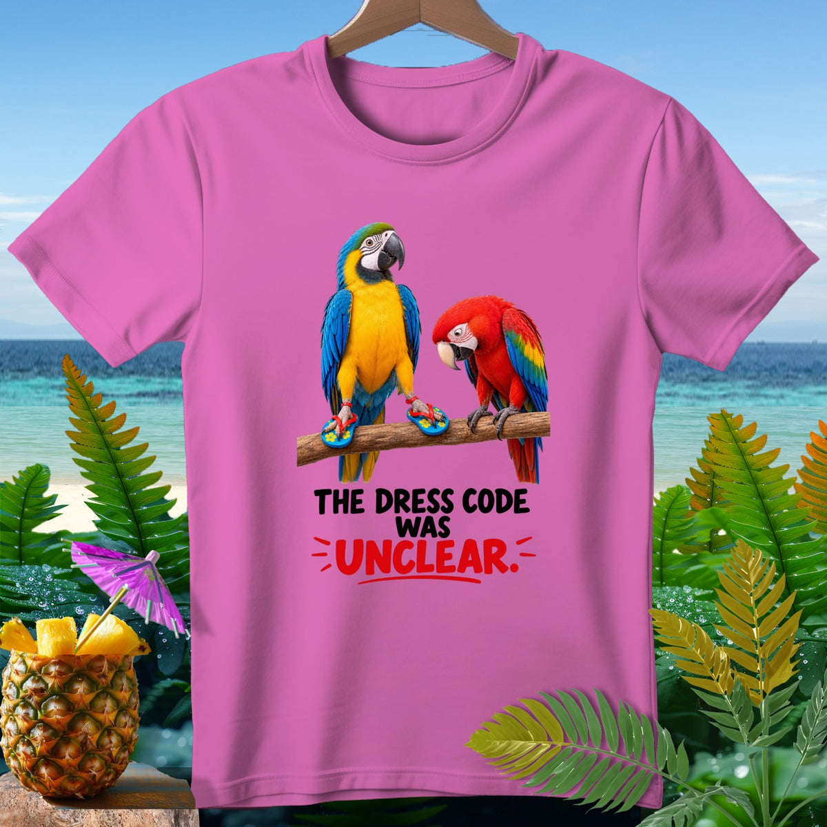 Pink t-shirt with two parrots and text that reads "THE DRESS CODE WAS UNCLEAR."