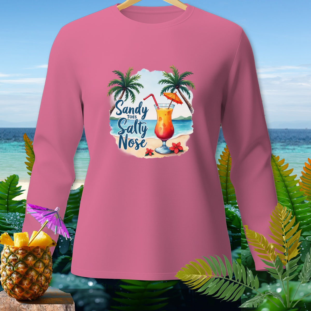 Pink long-sleeve shirt with a tropical beach graphic and "Sandy Toes Salty Nose" text.