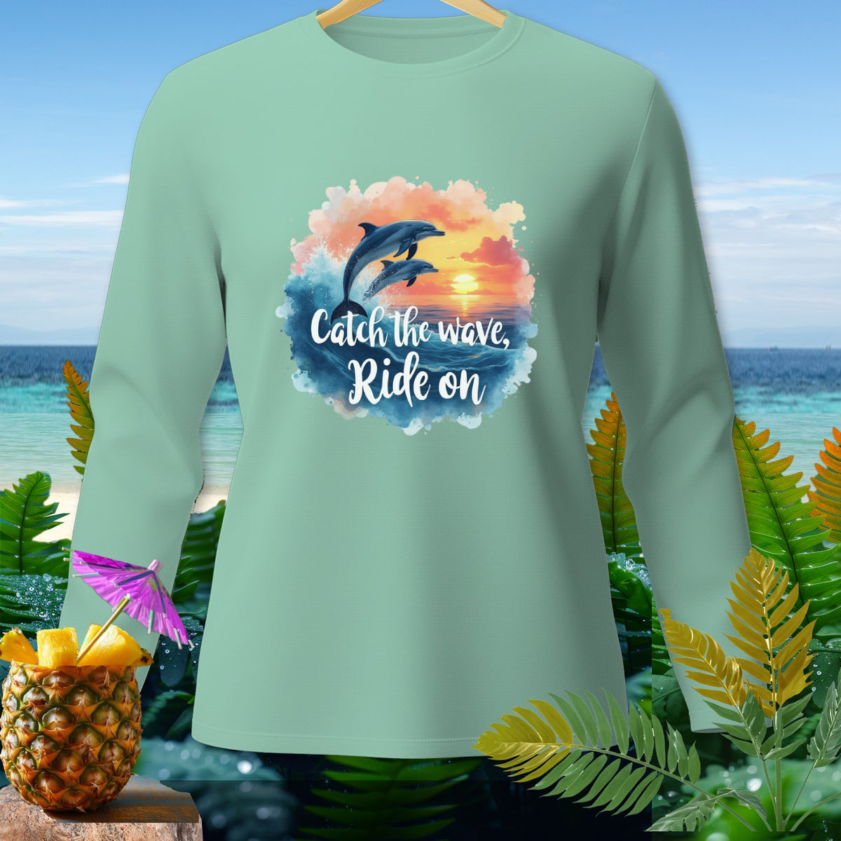 Green long-sleeve shirt with two dolphins jumping over waves and the text "Catch the wave, Ride on".