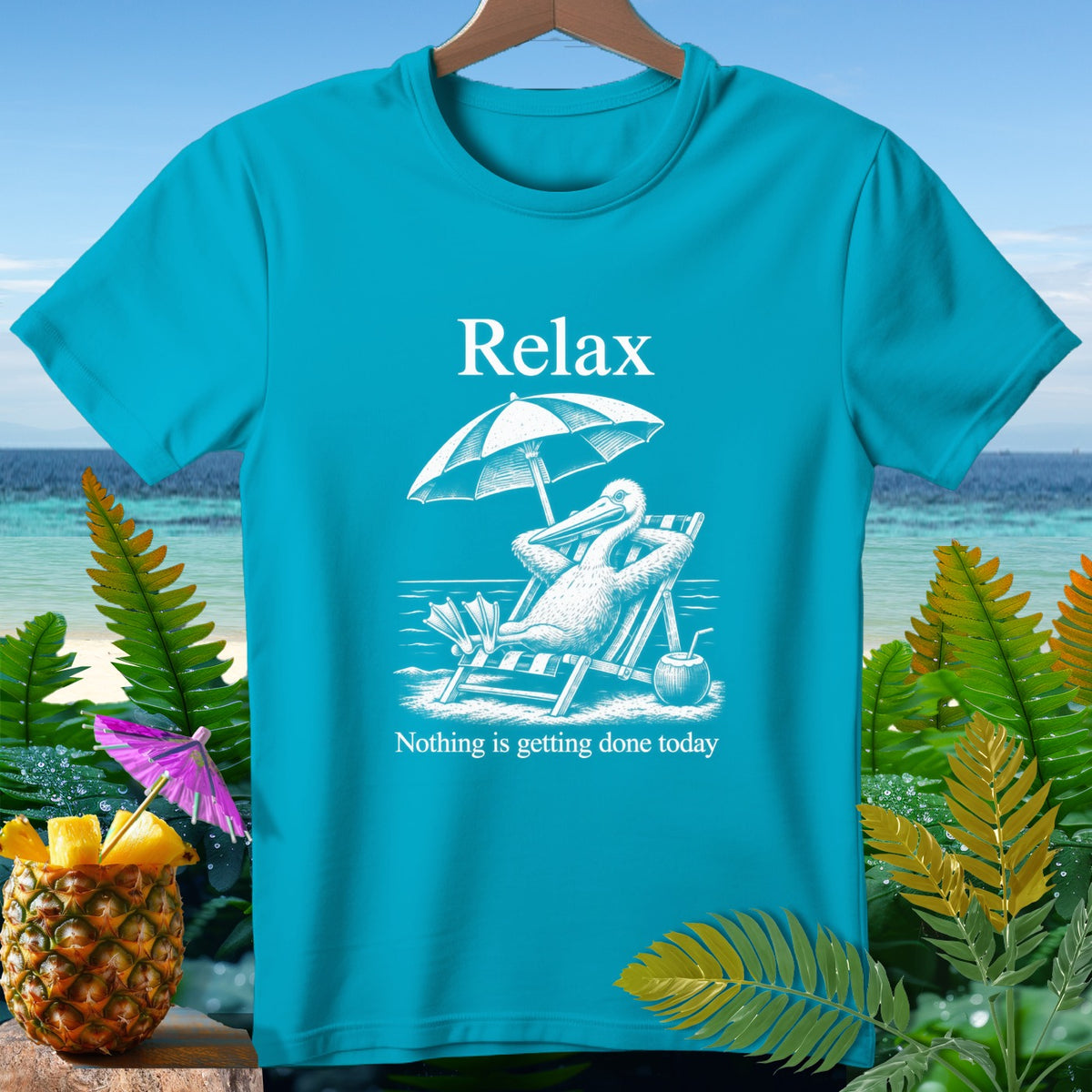 Turquoise t-shirt with a graphic of a pelican relaxing in a beach chair under an umbrella.
