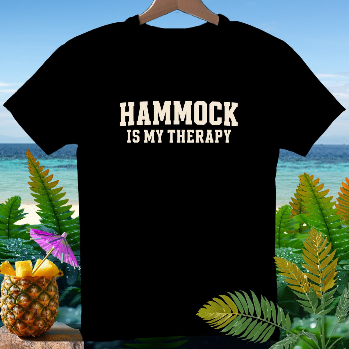 Black t-shirt with "HAMMOCK IS MY THERAPY" text over a tropical beach scene.