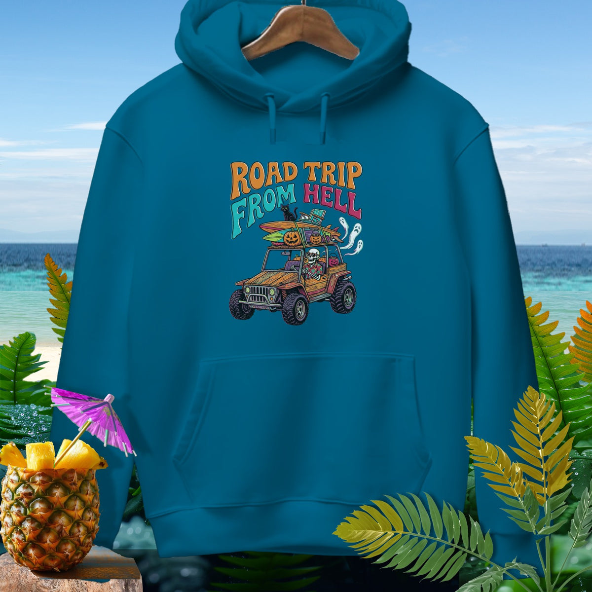 Teal hoodie with "Road Trip From Hell" graphic featuring a skeleton driving a jeep with Halloween decorations.