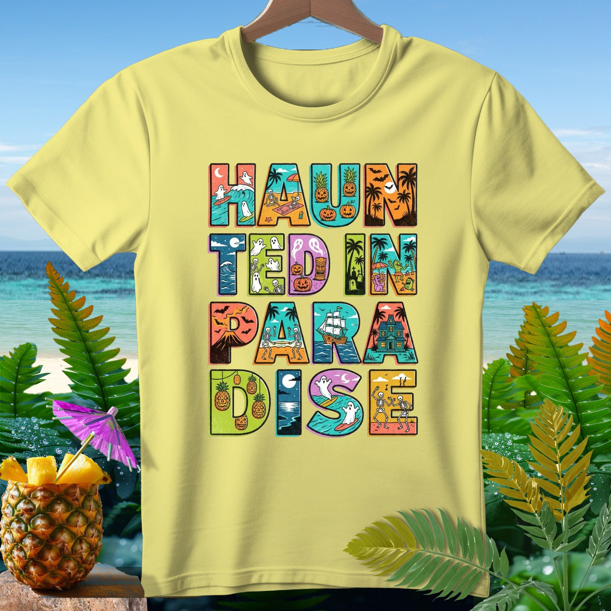 Yellow t-shirt with "HAUNTED IN PARADISE" text featuring Halloween and beach imagery.