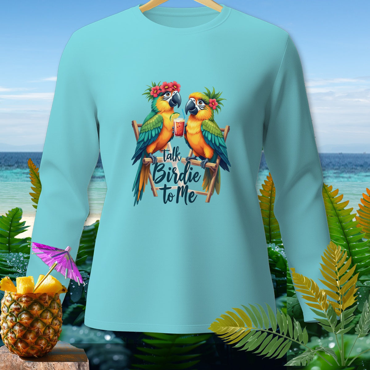 Light blue long-sleeve shirt with two parrots drinking cocktails and "Talk Birdie to Me" text.