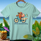 Light blue t-shirt graphic: crab on bicycle with surfboard, text 