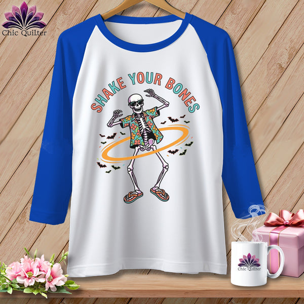 White baseball tee with a dancing skeleton graphic and "Shake Your Bones" text.
