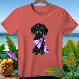 Coral t-shirt with black dachshund wearing a purple floral bandana on a beach background.