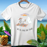 White t-shirt with skeleton and ghost on beach, text reads 