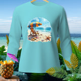 Light blue long-sleeved shirt with a beach scene graphic including an umbrella, chair, and flip-flops.