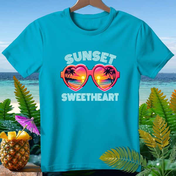 Blue t-shirt with "Sunset Sweetheart" text and heart-shaped sunglasses with sunset scene.
