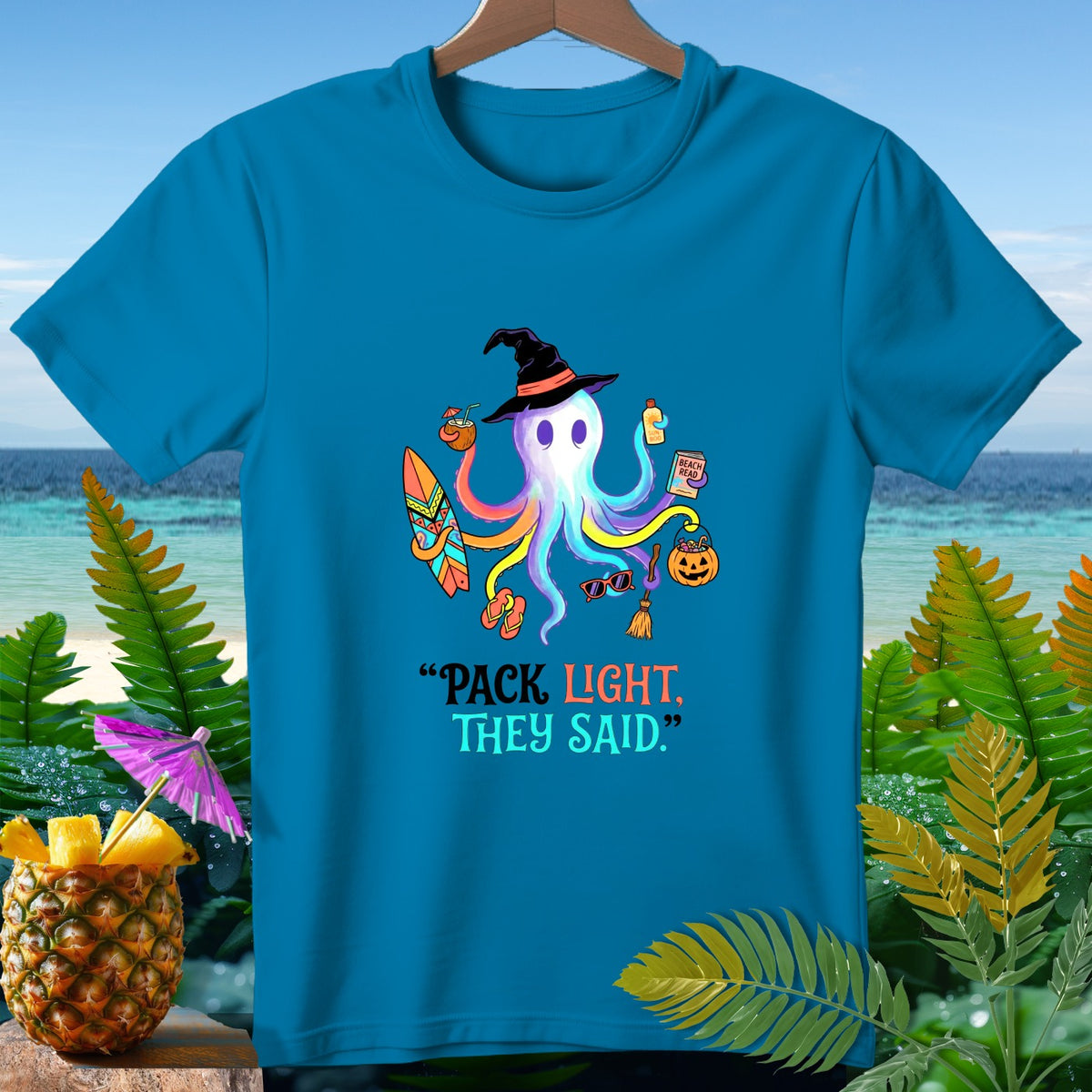 Octopus with witch hat, surfboard, coconut drink, and Halloween items with text "PACK LIGHT, THEY SAID."