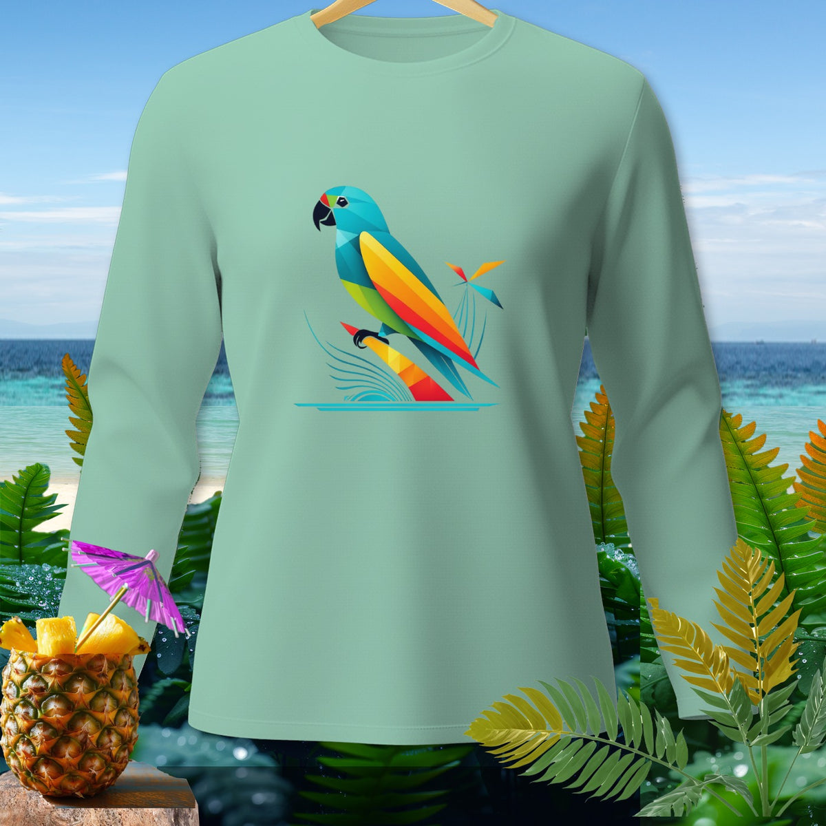 Light green long-sleeve shirt with colorful abstract parrot graphic on a beach background.