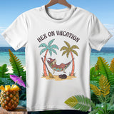 White t-shirt with a witch relaxing in a hammock on a beach, with text 