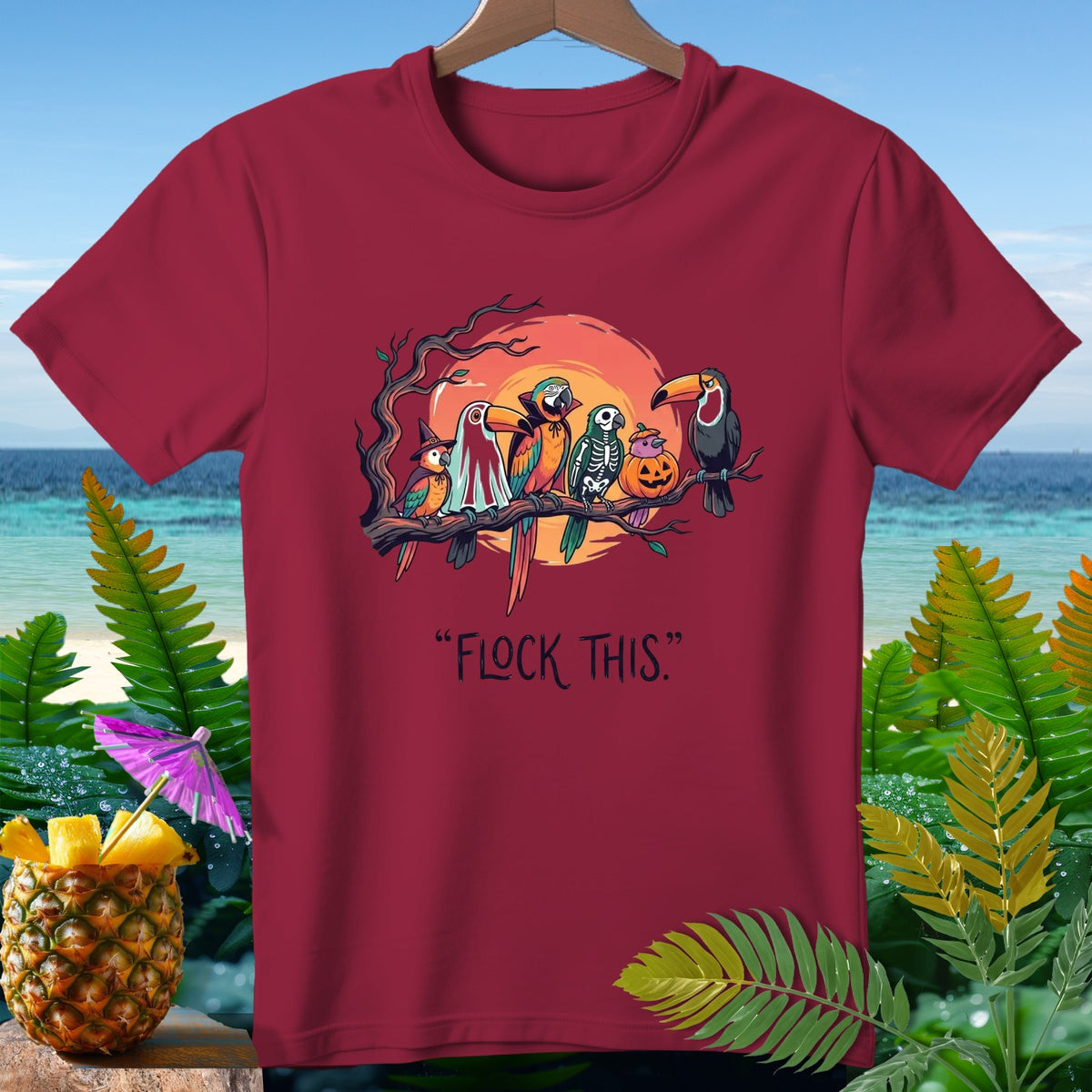 Maroon t-shirt with Halloween-themed parrots, skeleton, and pumpkin graphic.