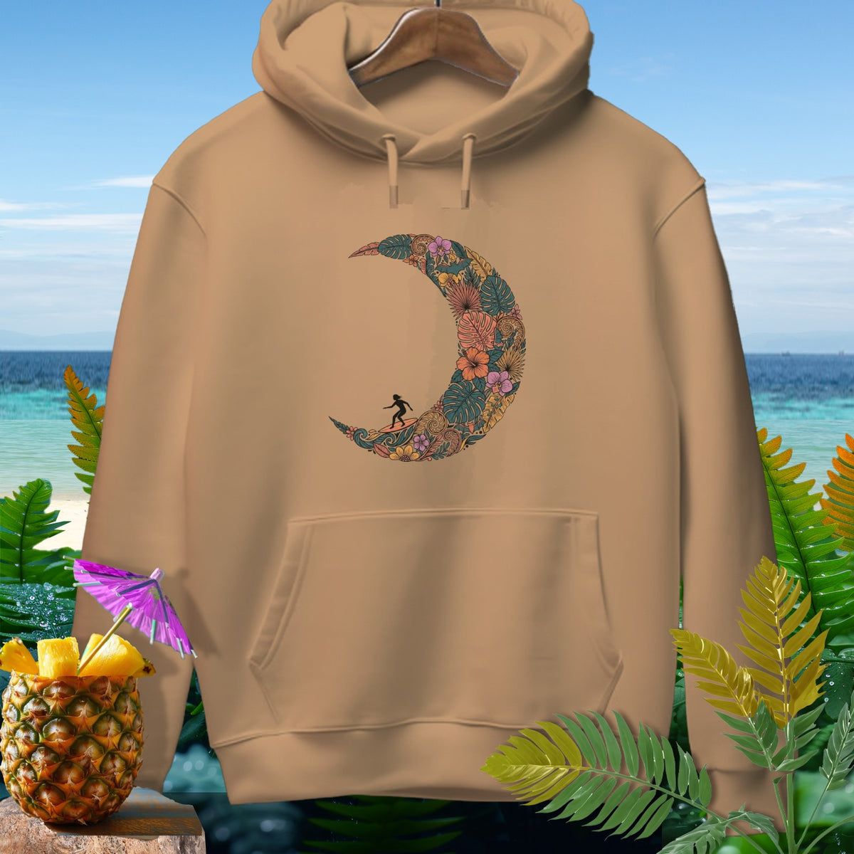 Brown hoodie with a crescent moon design featuring tropical flowers and a surfer.