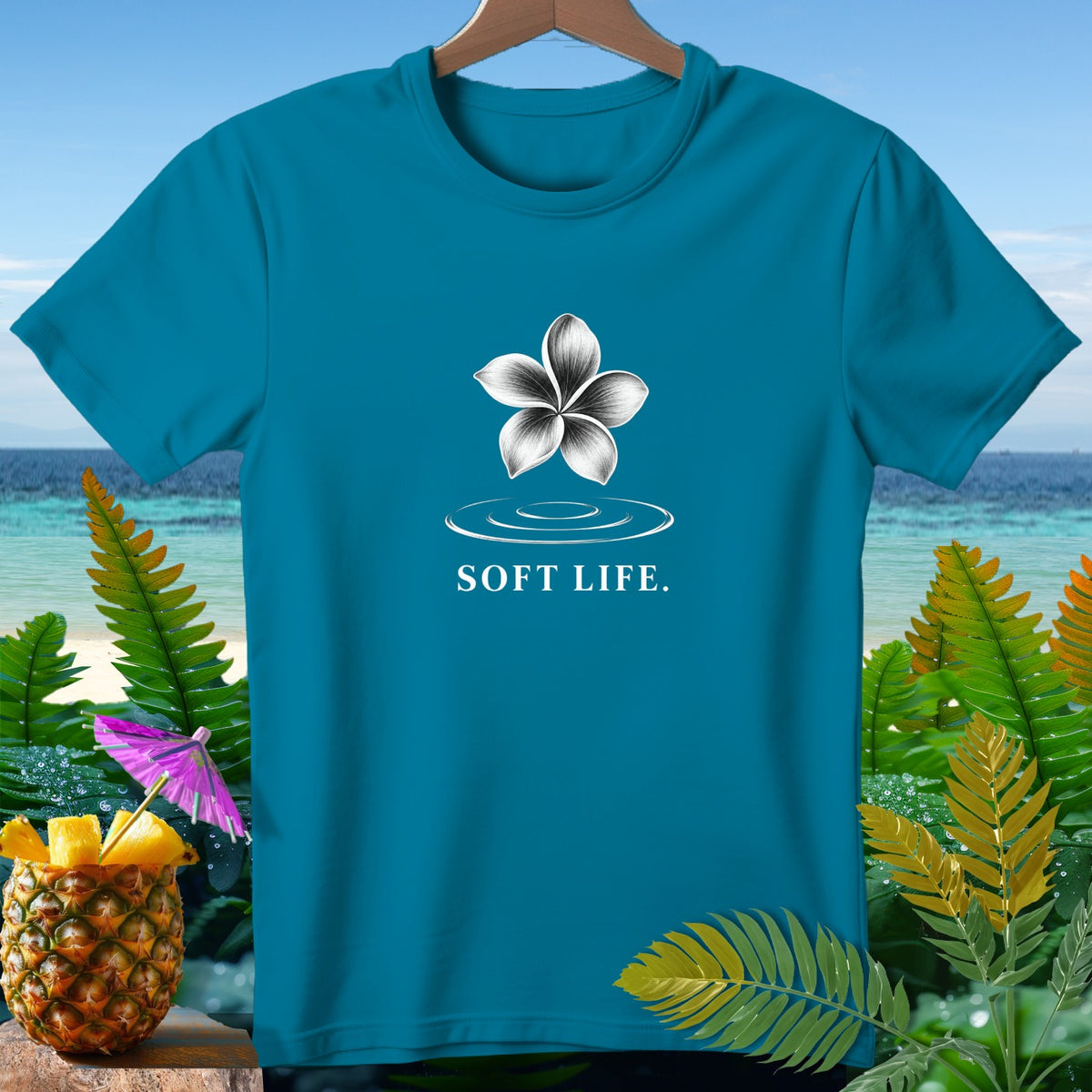 Teal t-shirt with a white flower graphic and "SOFT LIFE." text.